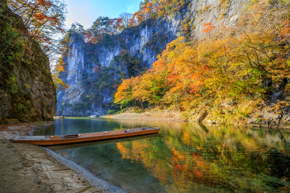 fall leaves in iwate along river with boat