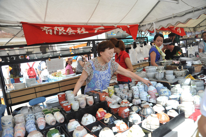 A pottery dealer presents her wide selection dishes to potential buyers during the Seto Pottery Autumn Festival held in Seto